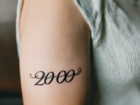 A-woman-with-a-2000-tattoo-on-her-upper-arm