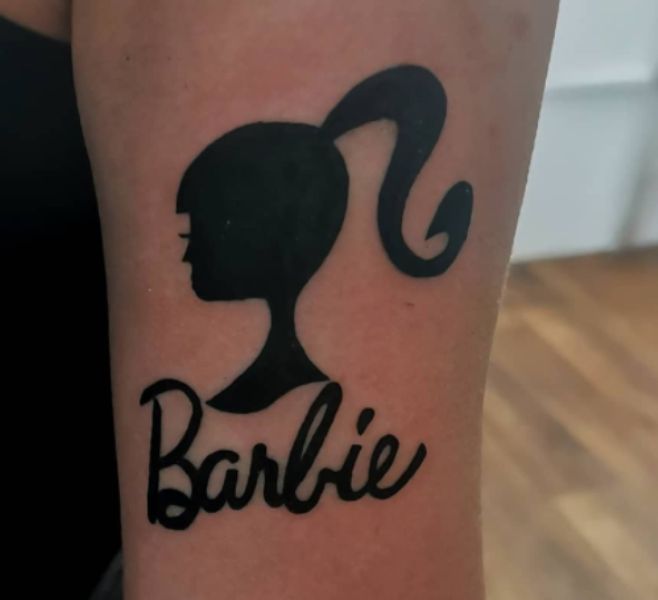 Black Barbie Head Tattoo Design on Forearm
