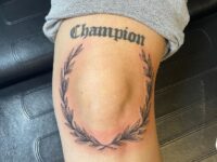 Champion-around-the-knee-tattoo