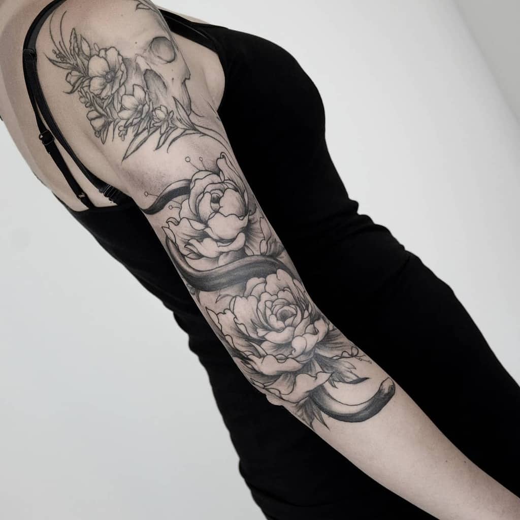 Floral themed 3/4 sleeve tattoo with artistic designs
