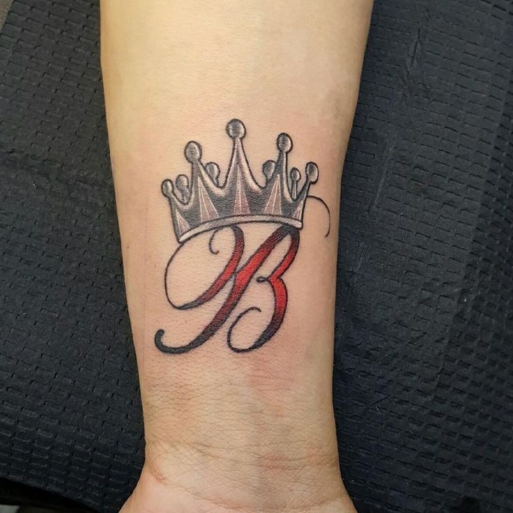 Letter B tattoo with crown on forearm