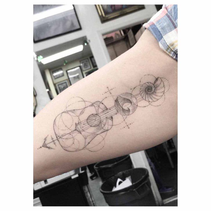 Cool acoustic guitar tattoo on forearm