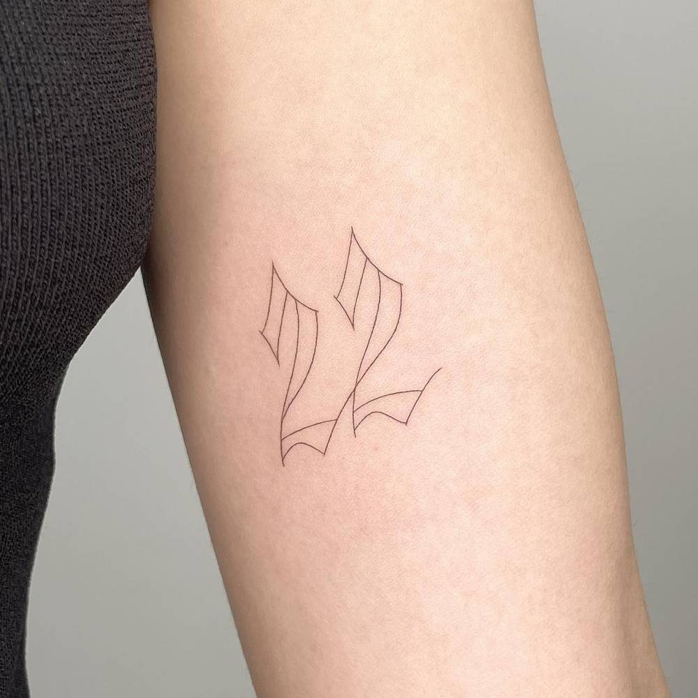 Tattoo of the number '22' located on the inner arm.