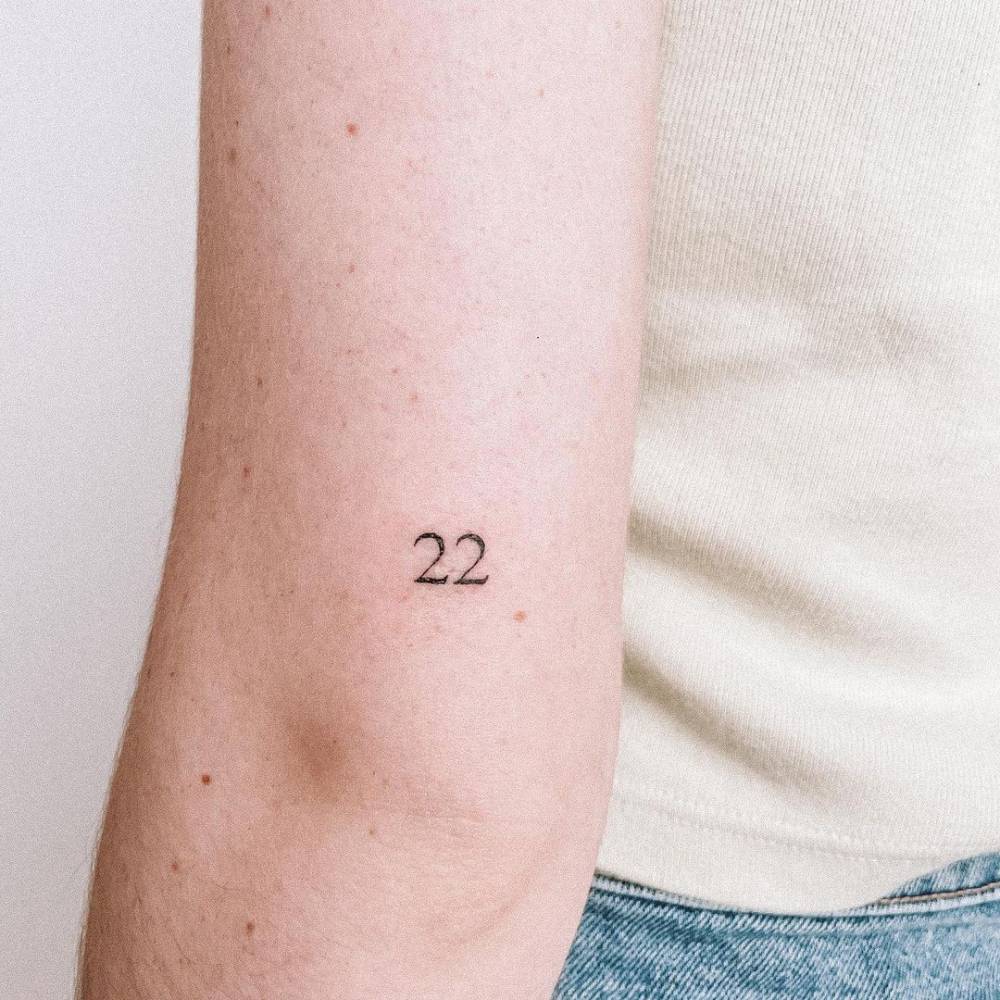 "22" lettering tattoo on the tricep.
