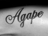 mens-black-ink-script-agape-lettering-tattoo-on-arm